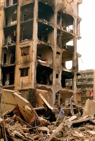 <p><b>NEW BEGINNINGS</b><br>
Now unencumbered by hate or bitterness, Lebanese men walk through the rubble of their former apartment buildings.</p>